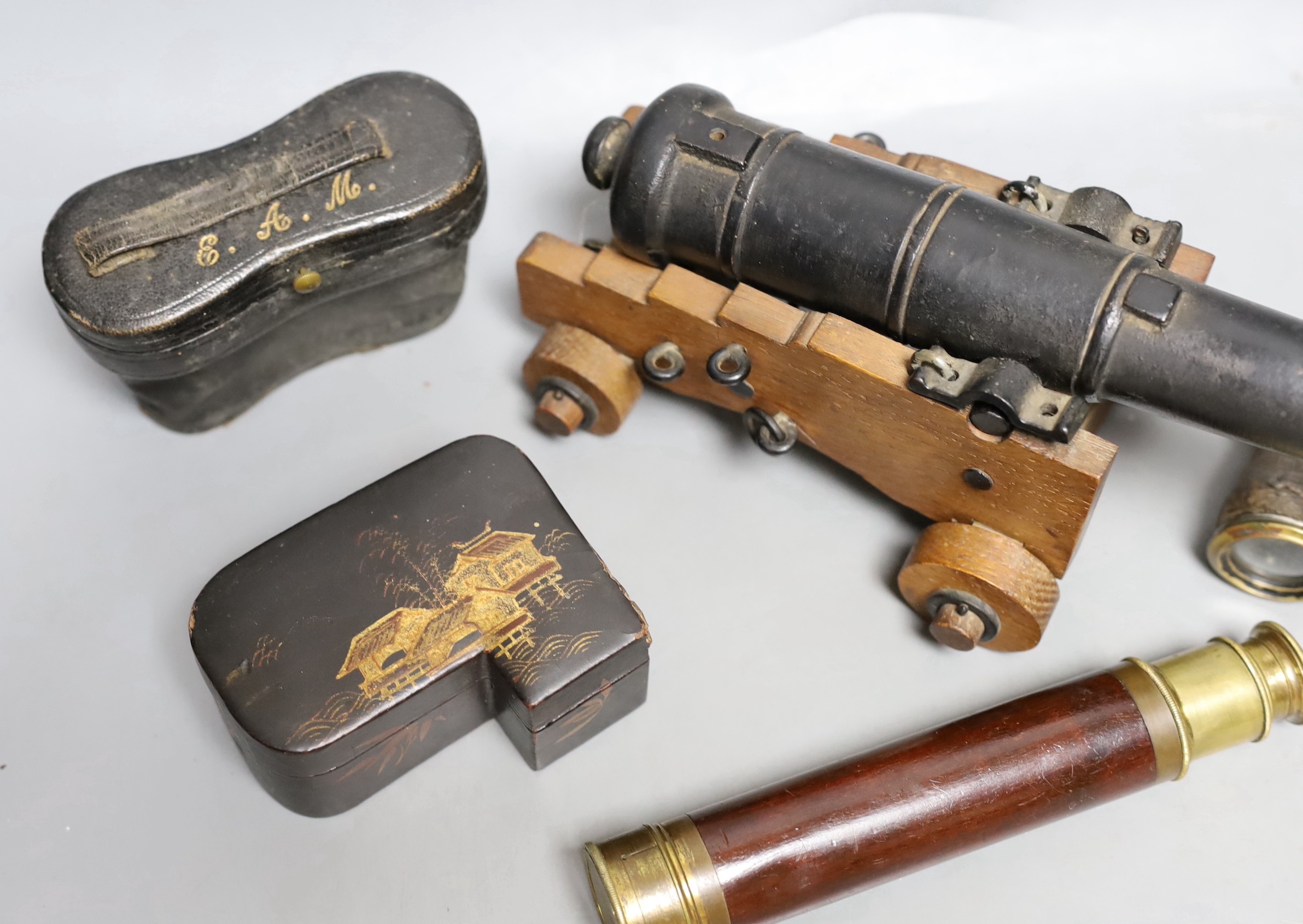 A model cast iron cannon on oak carriage, 26 cm long, two pairs of opera glasses, a telescope and lacquer box